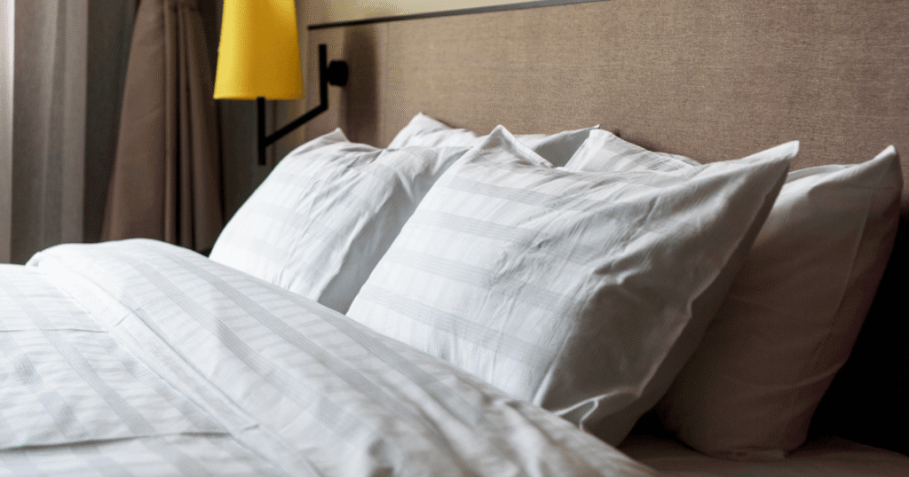 Cama arrumada com um jogo de cama, exemplificando como escolher o jogo de cama perfeito.