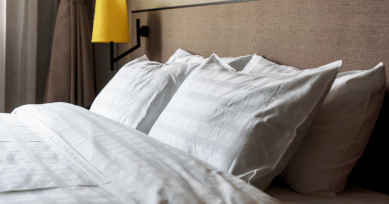 Cama arrumada com um jogo de cama, exemplificando como escolher o jogo de cama perfeito.