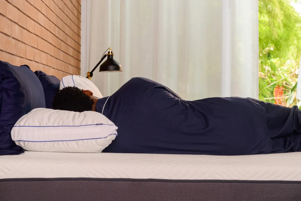 Pessoa dormindo de lado com o travesseiro na altura correta, garantindo o alinhamento da coluna.